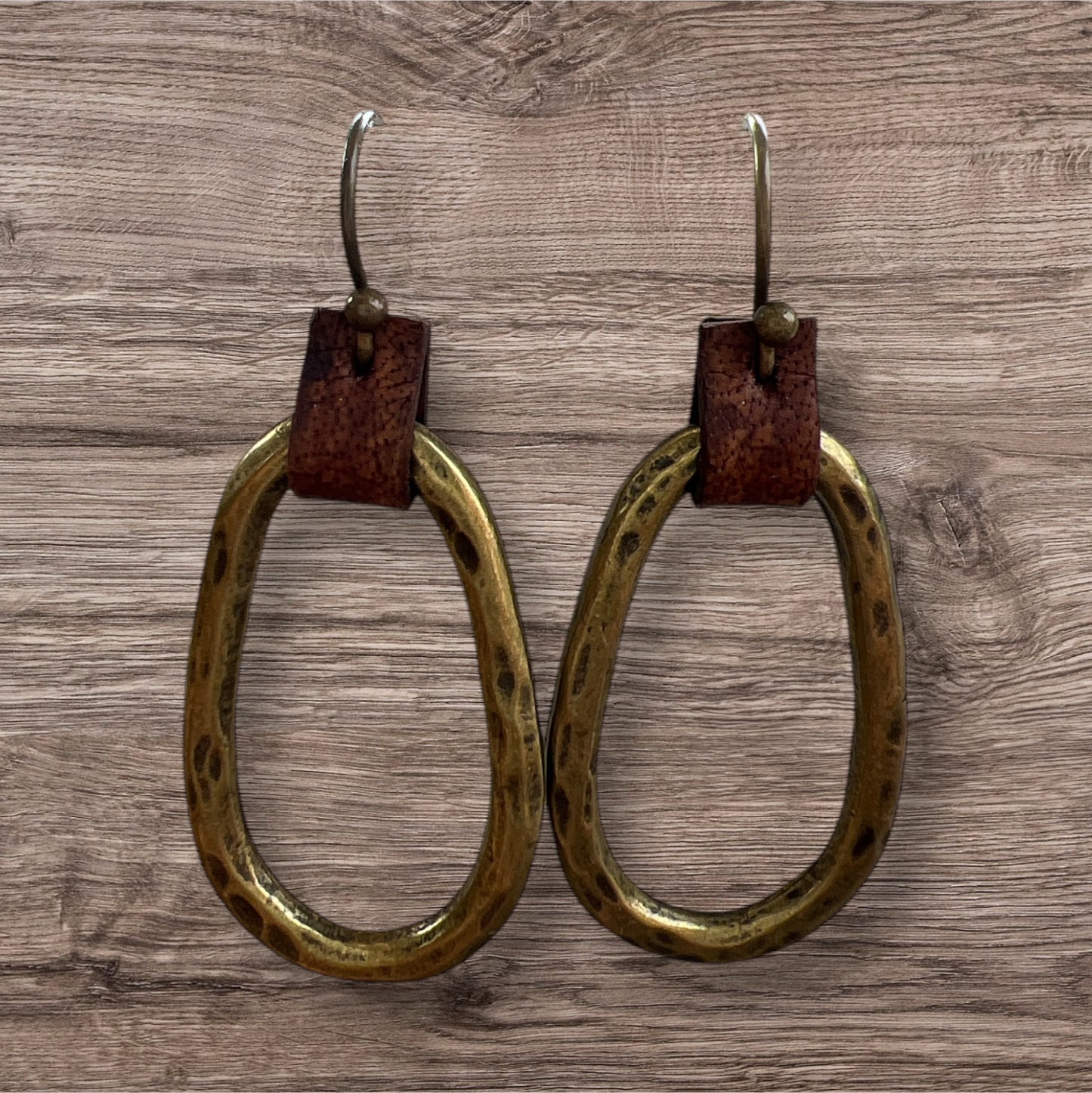 Leather and metal earrings with a sleek, modern design featuring a combination of textured leather and metallic accents.
