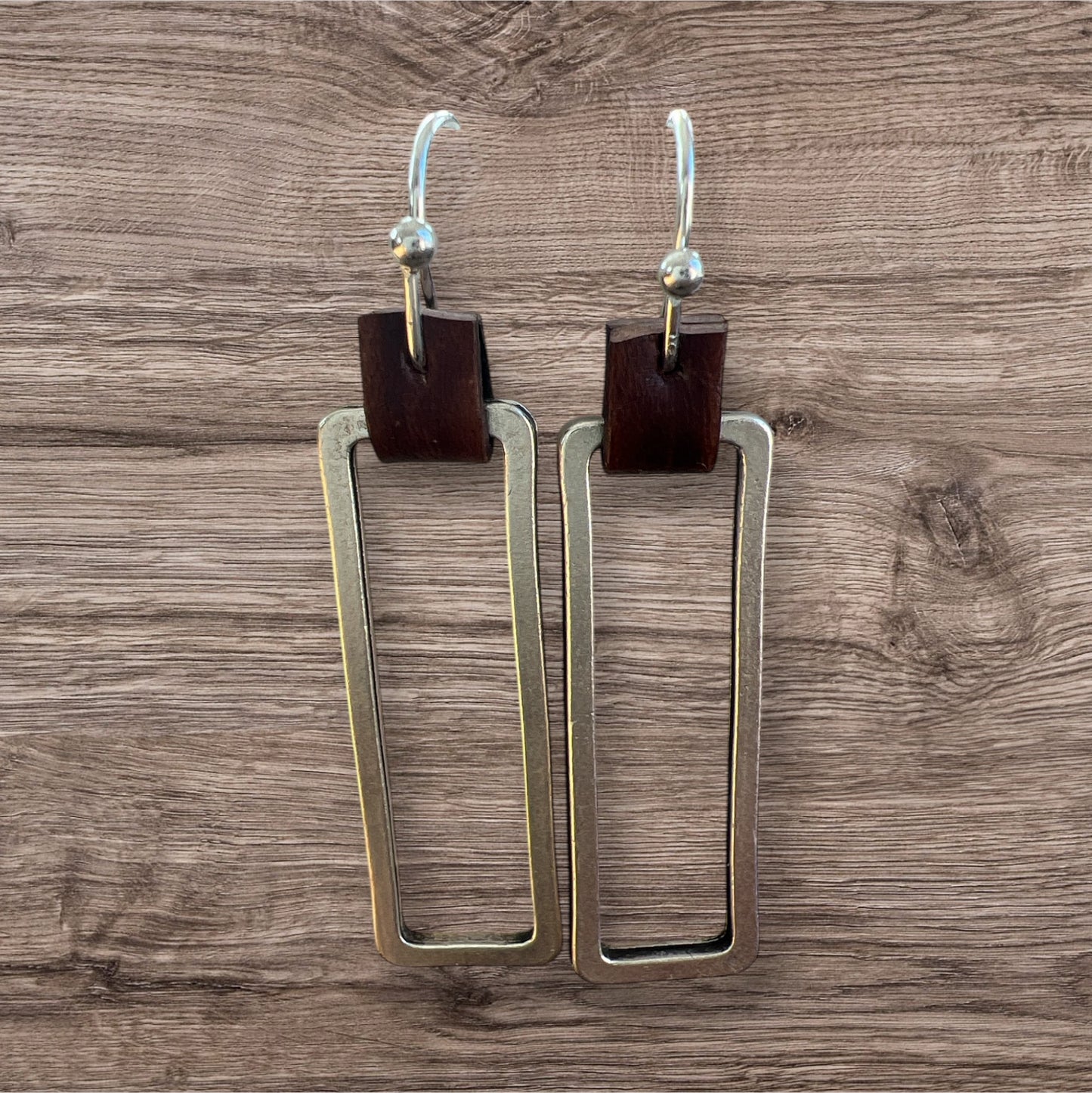 Leather and metal earrings with a sleek, modern design featuring a combination of textured leather and metallic accents.