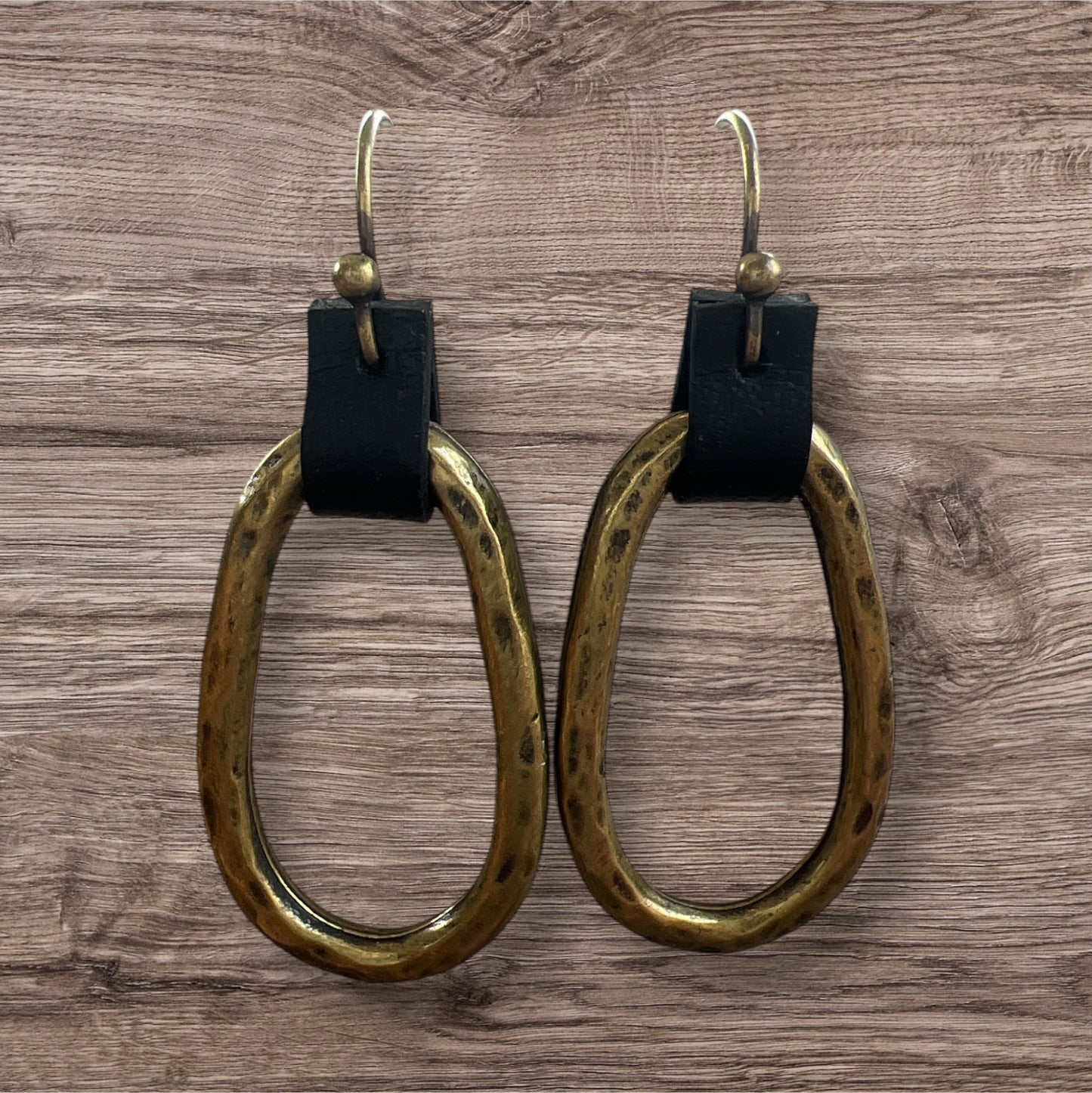 Leather and metal earrings with a sleek, modern design featuring a combination of textured leather and metallic accents.