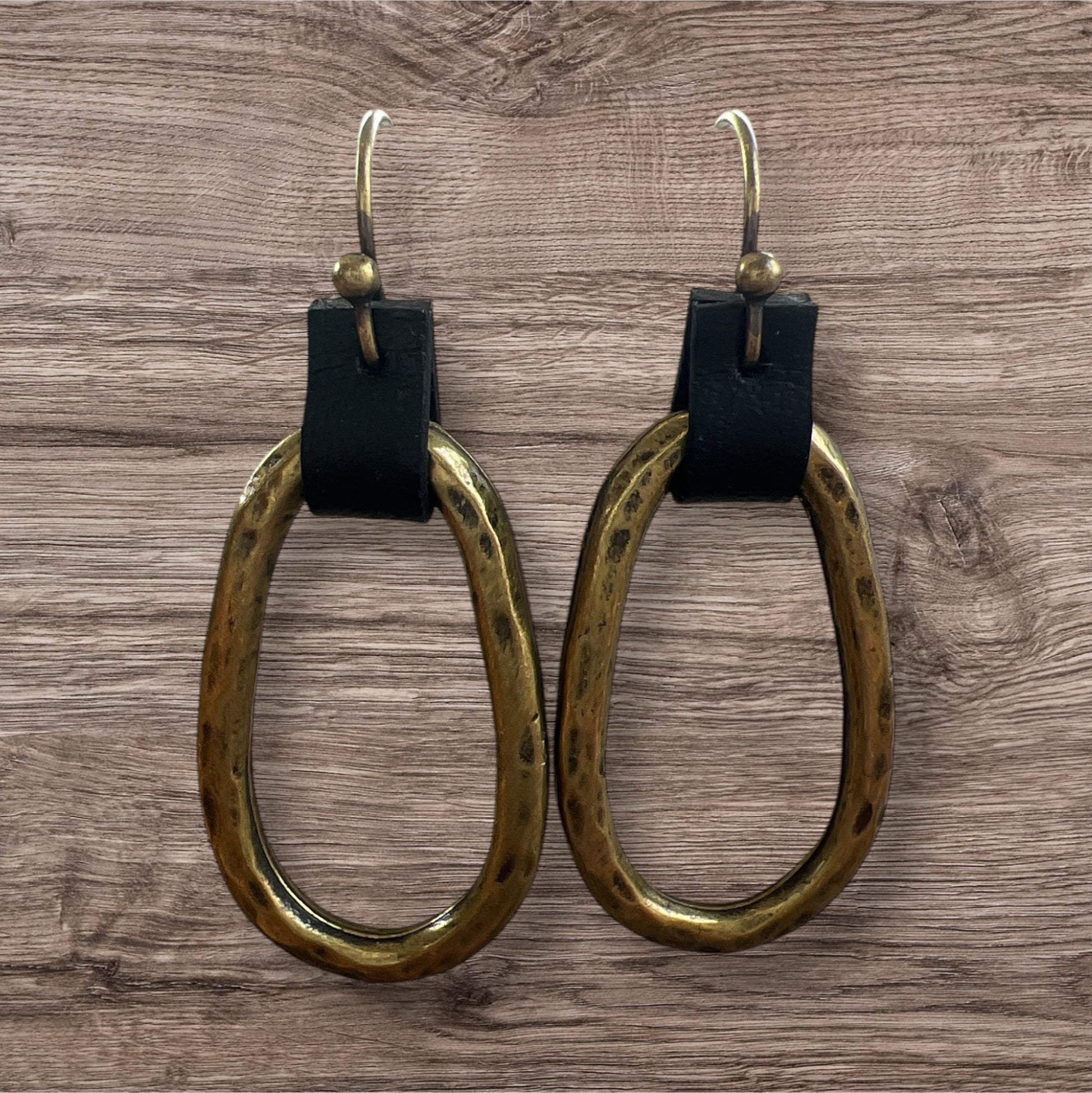 Leather and metal earrings with a sleek, modern design featuring a combination of textured leather and metallic accents.