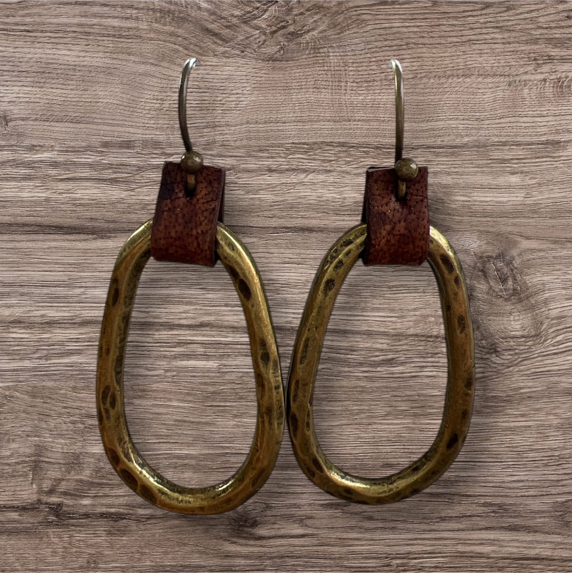 Leather and metal earrings with a sleek, modern design featuring a combination of textured leather and metallic accents.