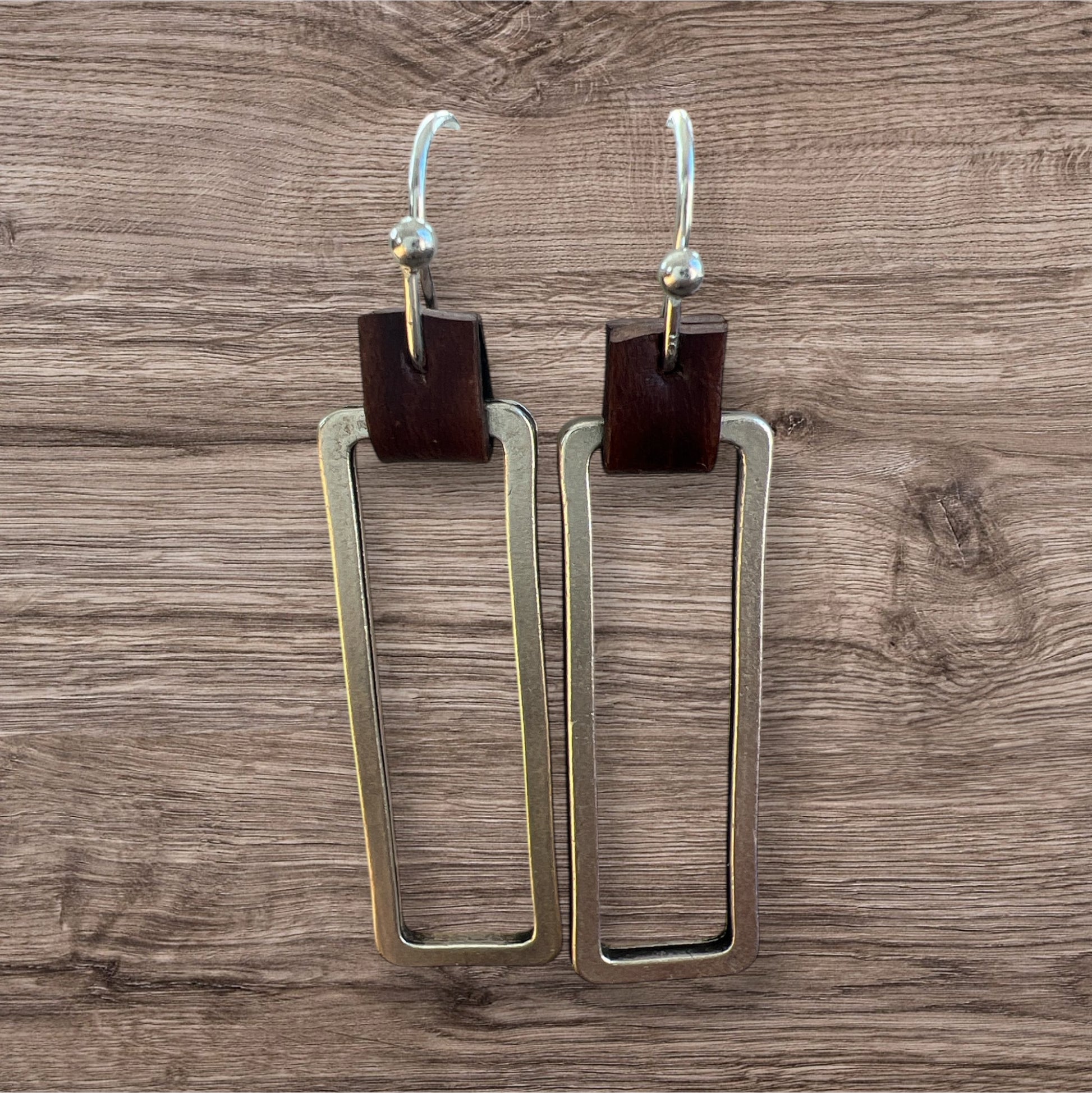 Leather and metal earrings with a sleek, modern design featuring a combination of textured leather and metallic accents.